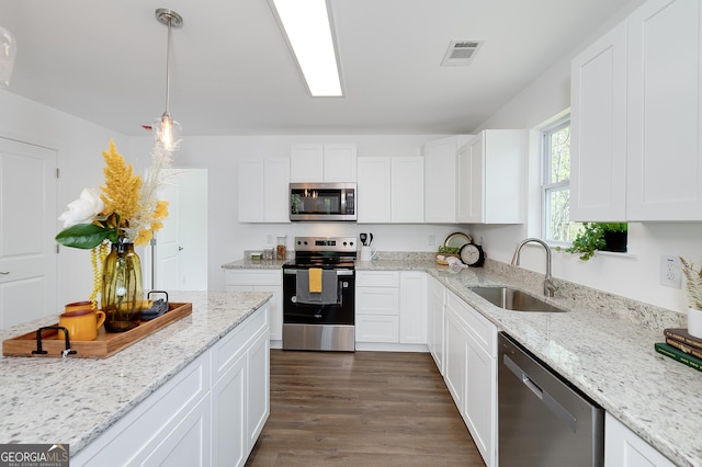 100 N Stewart Ln, Griffin, GA 30224 - kitchen with dark wood-style floors, white cabinetry, visible vents, stainless steel appliances, and a sink