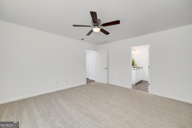 100 N Stewart Ln, Griffin, GA 30224 - unfurnished bedroom with dark carpet, baseboards, connected bathroom, and ceiling fan