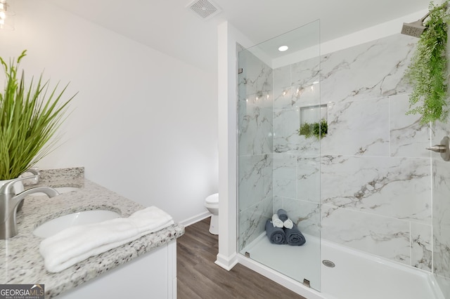 100 N Stewart Ln, Griffin, GA 30224 - full bathroom featuring visible vents, toilet, wood finished floors, a marble finish shower, and baseboards