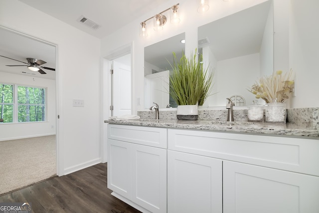 100 N Stewart Ln, Griffin, GA 30224 - full bath with baseboards, double vanity, a ceiling fan, visible vents, and wood finished floors