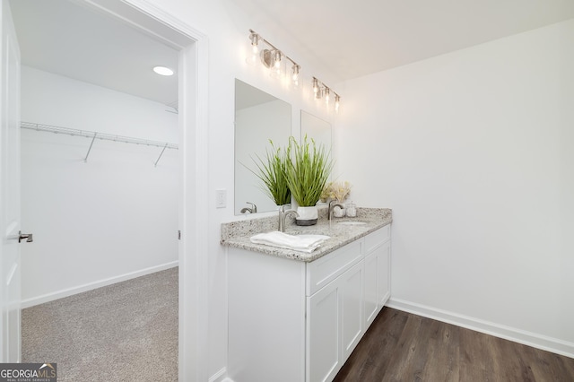 100 N Stewart Ln, Griffin, GA 30224 - bathroom with baseboards, a walk in closet, vanity, and wood finished floors