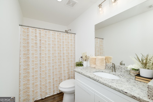 100 N Stewart Ln, Griffin, GA 30224 - full bathroom with toilet, wood finished floors, vanity, and visible vents