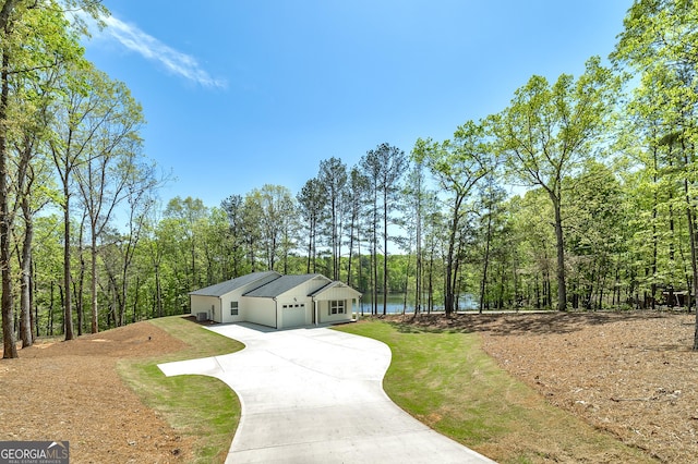 100 N Stewart Ln, Griffin, GA 30224 - view of front of home featuring an attached garage, a view of trees, concrete driveway, and a front yard