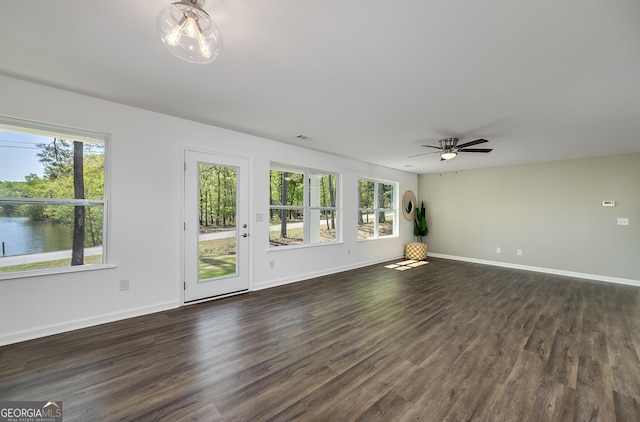 100 N Stewart Ln, Griffin, GA 30224 - unfurnished living room featuring a water view, baseboards, a ceiling fan, and dark wood finished floors