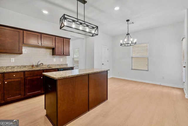 7431 Saint David St, Fairburn, GA 30213 - kitchen with a chandelier, backsplash, a center island, light stone counters, and decorative light fixtures