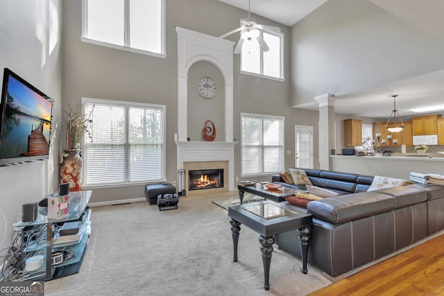 1812 Mountain Lake Dr NW, Kennesaw, GA 30152 - living area with a high ceiling, a glass covered fireplace, plenty of natural light, ceiling fan, and light colored carpet