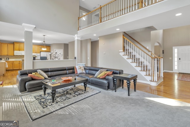 1812 Mountain Lake Dr NW, Kennesaw, GA 30152 - living area with a towering ceiling, stairs, ornate columns, light wood-type flooring, and recessed lighting