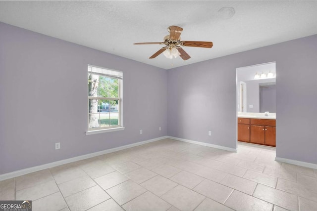 210 Preakness Dr, Hinesville, GA 31313 - unfurnished bedroom featuring baseboards, light tile patterned floors, ensuite bath, ceiling fan, and a sink
