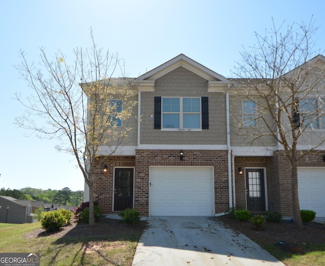 view of property featuring brick siding, an attached garage, and concrete driveway