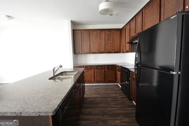 kitchen with stone counters, dark wood-style floors, black appliances, visible vents, and a sink