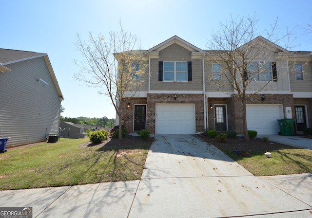 townhome / multi-family property with a front yard, central AC, an attached garage, brick siding, and driveway