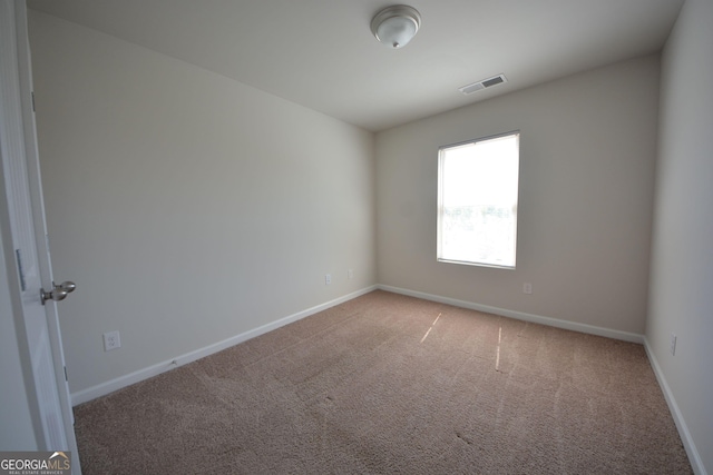 carpeted empty room with baseboards and visible vents