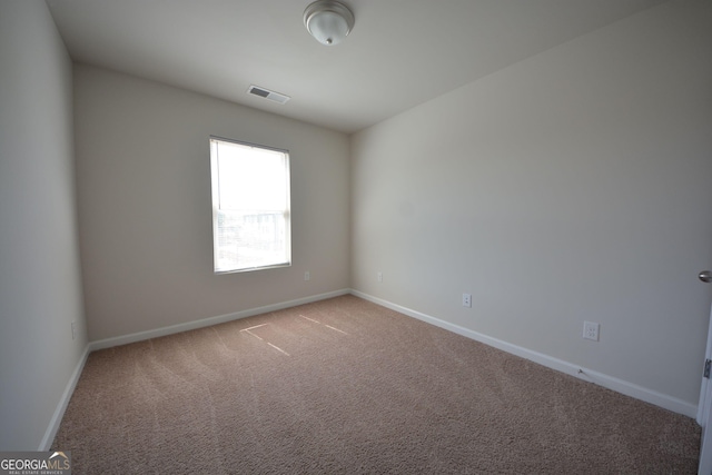 carpeted spare room with baseboards and visible vents