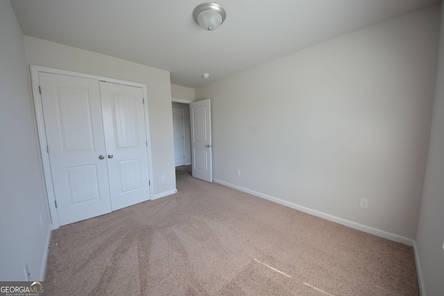 unfurnished bedroom featuring a closet, baseboards, and carpet flooring