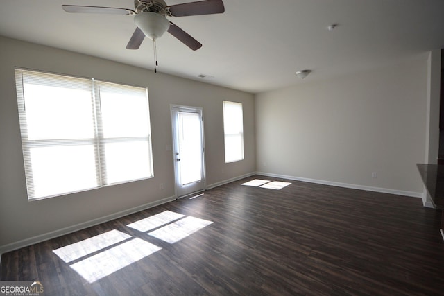 unfurnished living room with visible vents, baseboards, and dark wood finished floors
