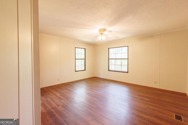 spare room featuring a ceiling fan, crown molding, wood finished floors, and visible vents