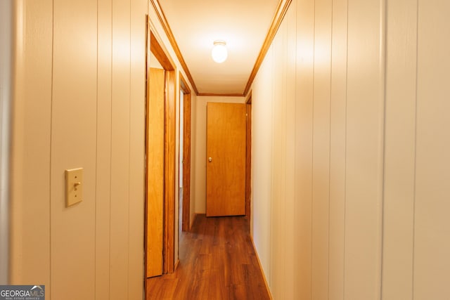 hall with wood finished floors and ornamental molding
