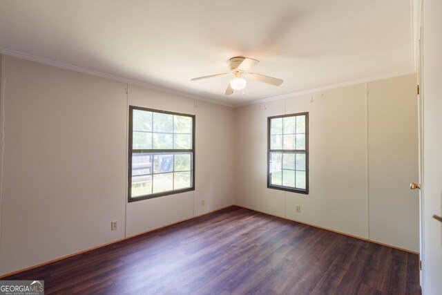 unfurnished room featuring dark wood finished floors, a ceiling fan, and crown molding