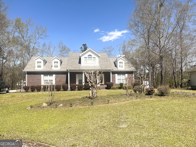 cape cod home featuring brick siding, a front lawn, and a porch