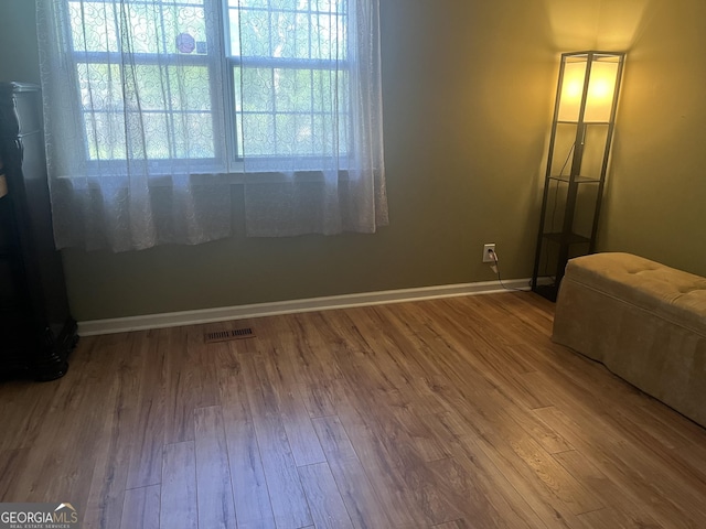bedroom featuring visible vents, baseboards, and wood finished floors