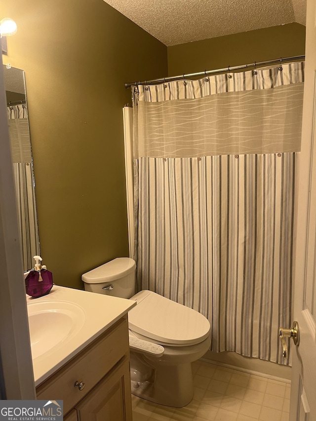 full bath featuring tile patterned floors, vanity, a textured ceiling, and toilet