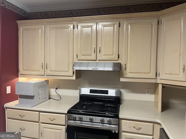 kitchen with under cabinet range hood, light countertops, backsplash, and stainless steel gas range oven