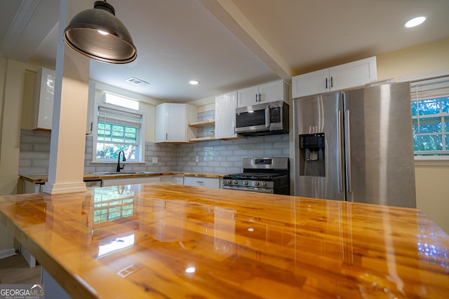 kitchen with tasteful backsplash, butcher block counters, visible vents, appliances with stainless steel finishes, and a sink