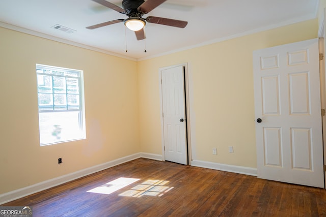 unfurnished bedroom with hardwood / wood-style floors, visible vents, crown molding, and baseboards