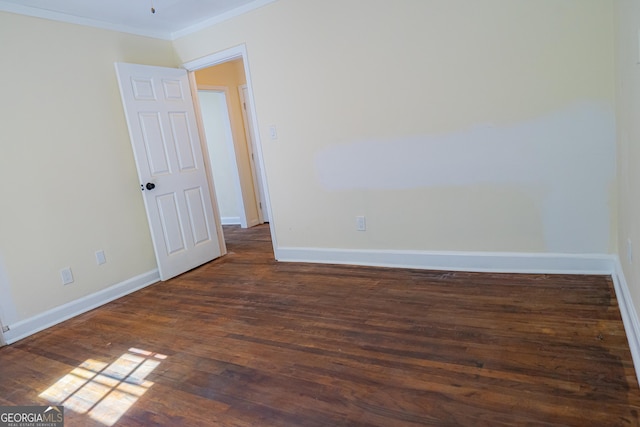 empty room with crown molding, baseboards, and dark wood-style flooring