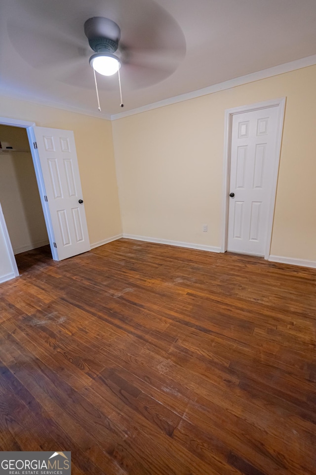 unfurnished room with dark wood-style flooring, baseboards, a ceiling fan, and crown molding