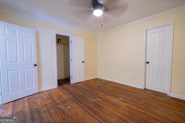 unfurnished bedroom featuring dark wood-style flooring, baseboards, a ceiling fan, and crown molding