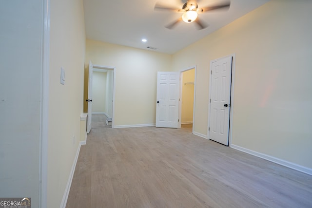 spare room with light wood-type flooring, a ceiling fan, visible vents, recessed lighting, and baseboards