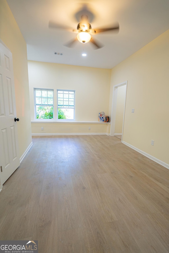 unfurnished living room with visible vents, a ceiling fan, baseboards, and light wood-style flooring