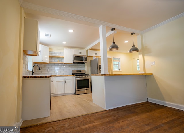 kitchen featuring decorative backsplash, appliances with stainless steel finishes, white cabinetry, and light wood-type flooring