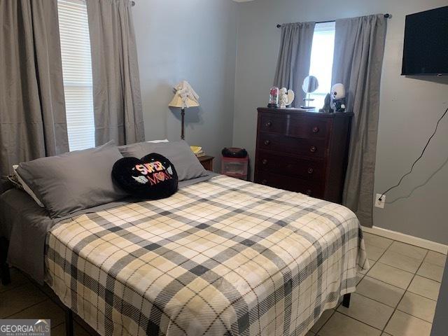 bedroom with tile patterned floors and baseboards