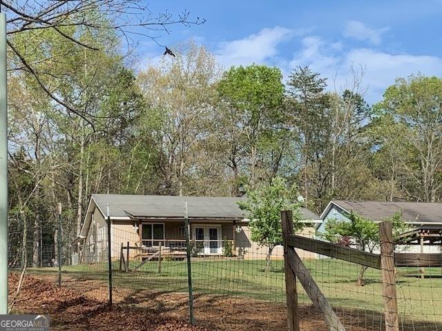 ranch-style home featuring a front lawn and a fenced front yard