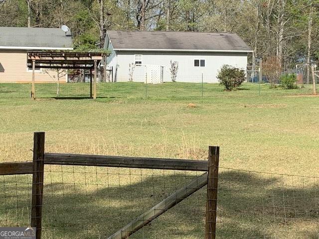 view of yard featuring a pergola and fence