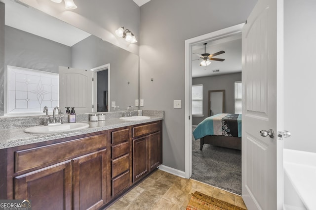 full bath featuring double vanity, a bathtub, ceiling fan, and a sink