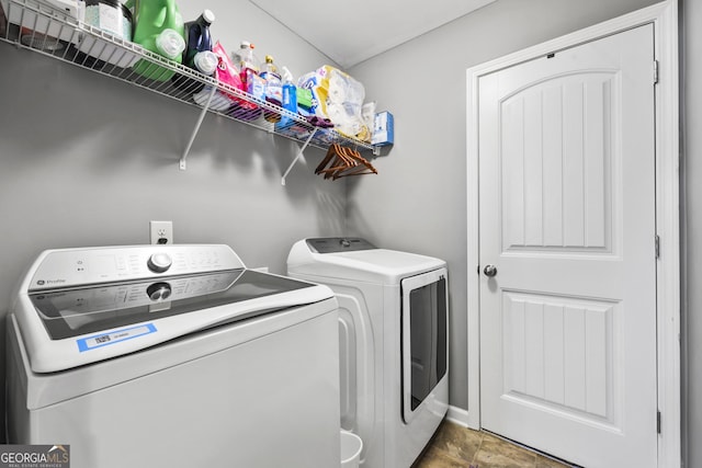 laundry room featuring stone finish floor, laundry area, and washing machine and dryer