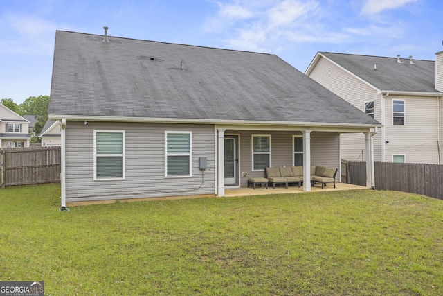 rear view of property featuring a lawn, a fenced backyard, a patio area, and an outdoor hangout area