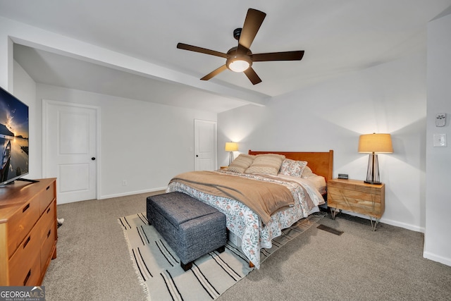 carpeted bedroom with baseboards, a ceiling fan, and beamed ceiling