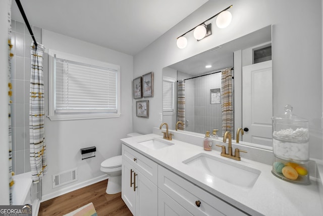 full bathroom featuring wood finished floors, visible vents, a sink, and toilet