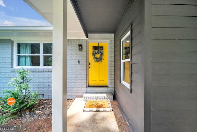 view of exterior entry featuring brick siding