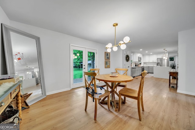 dining area with light wood-type flooring, french doors, baseboards, and an inviting chandelier