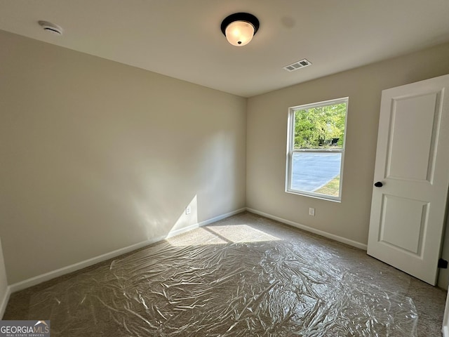 unfurnished room featuring baseboards and visible vents