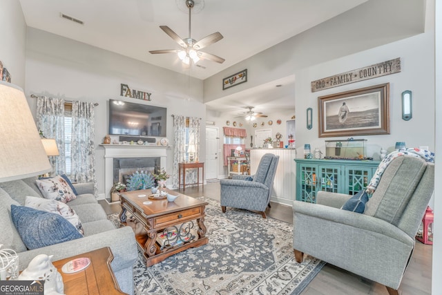 11 Bush Arbor Pl SW, Rome, GA 30165 - living room with a glass covered fireplace, a towering ceiling, visible vents, ceiling fan, and wood finished floors