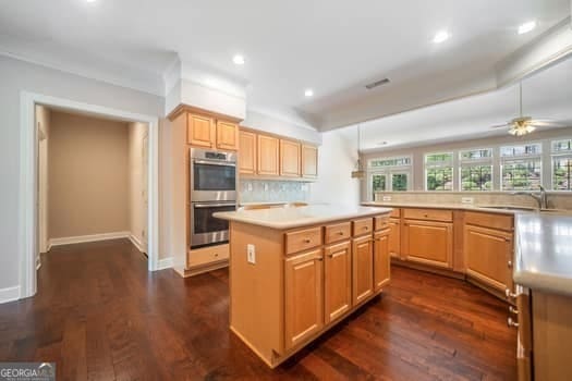 1330 Badingham Dr, Cumming, GA 30041 - kitchen with double oven, light countertops, a kitchen island, dark wood finished floors, and recessed lighting