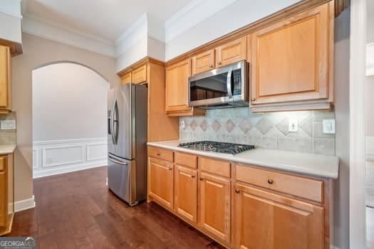 1330 Badingham Dr, Cumming, GA 30041 - kitchen featuring appliances with stainless steel finishes, arched walkways, light countertops, and ornamental molding