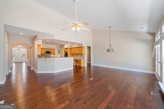 1330 Badingham Dr, Cumming, GA 30041 - unfurnished living room with a ceiling fan, arched walkways, dark wood finished floors, and recessed lighting
