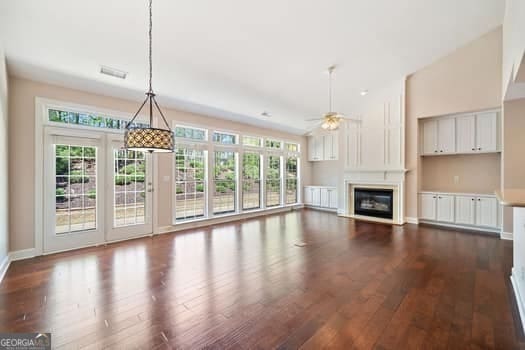 1330 Badingham Dr, Cumming, GA 30041 - unfurnished living room with dark wood-style floors, a ceiling fan, and healthy amount of natural light